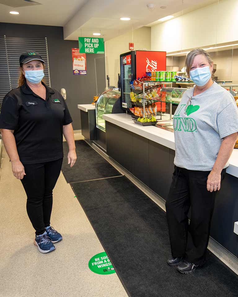 two dining employees standing in a convenience store